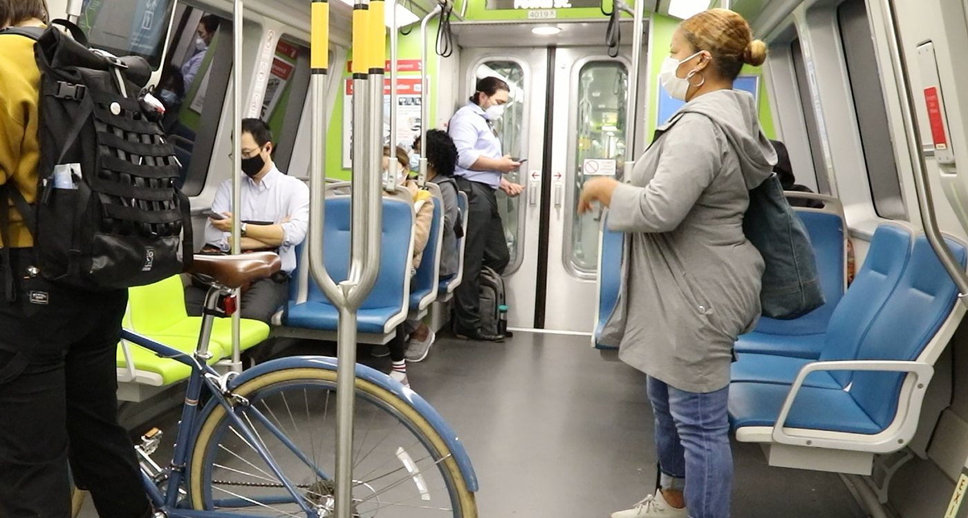 Several masked people riding public transit