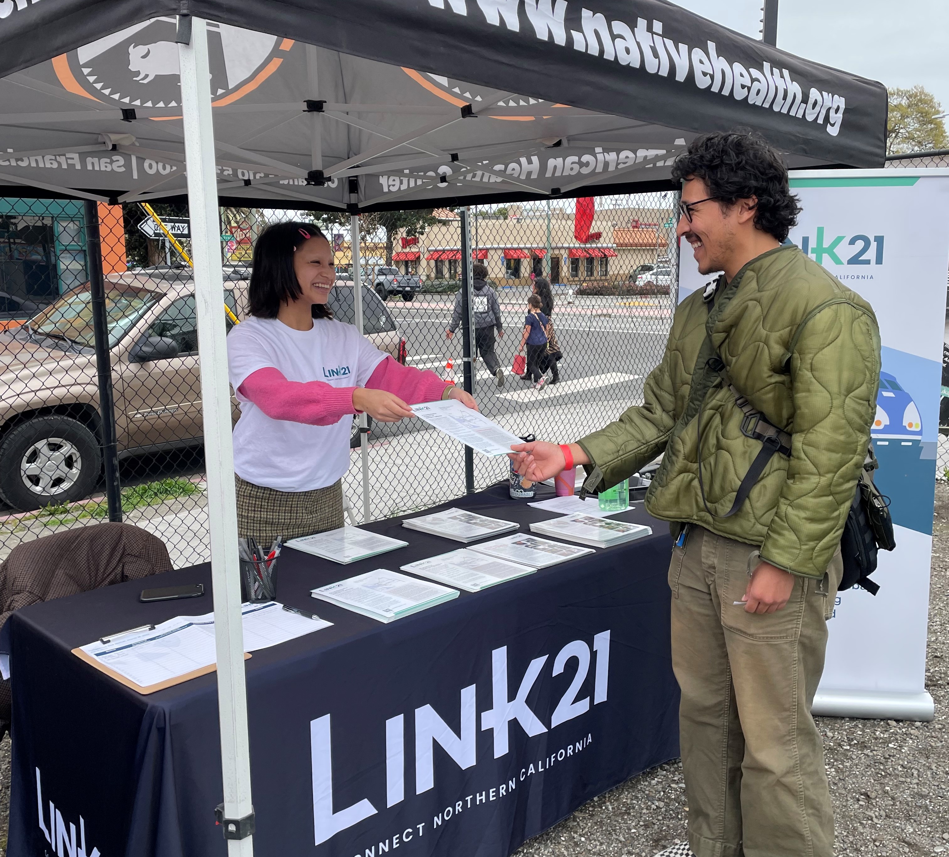 Community member talking to Link21 staff at a grassroots event