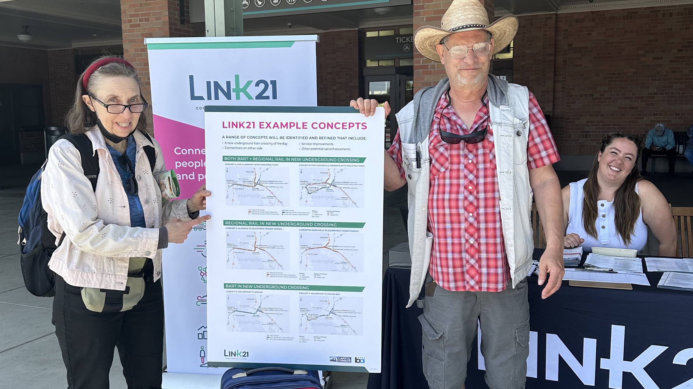 dos personas mayores que sostienen un póster de Link21 en un evento