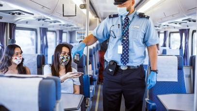 Conductor scanning tickets aboard Capitol Corridor